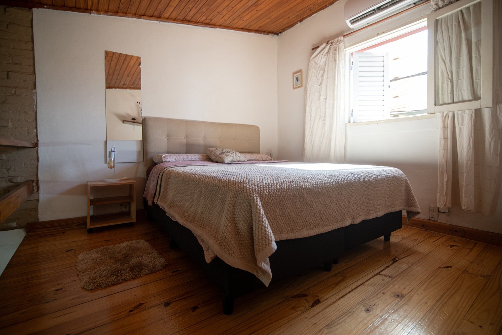 Dormitorio con cama matrimonial y piso de madera – Tempo A, Posadas