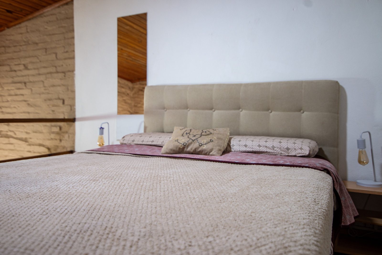 Cama matrimonial con pared de ladrillo visto – Tempo A, Posadas