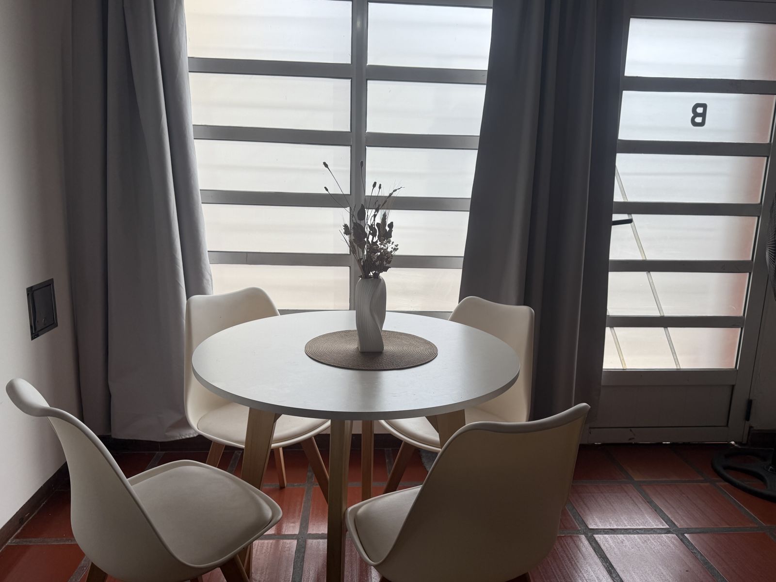 Comedor con mesa redonda blanca junto al ventanal – Tempo B, Posadas